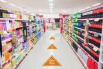 Store aisle with arrow-shaped TexWalk removable floor graphics, providing slip-resistant, durable signage for retail environments.