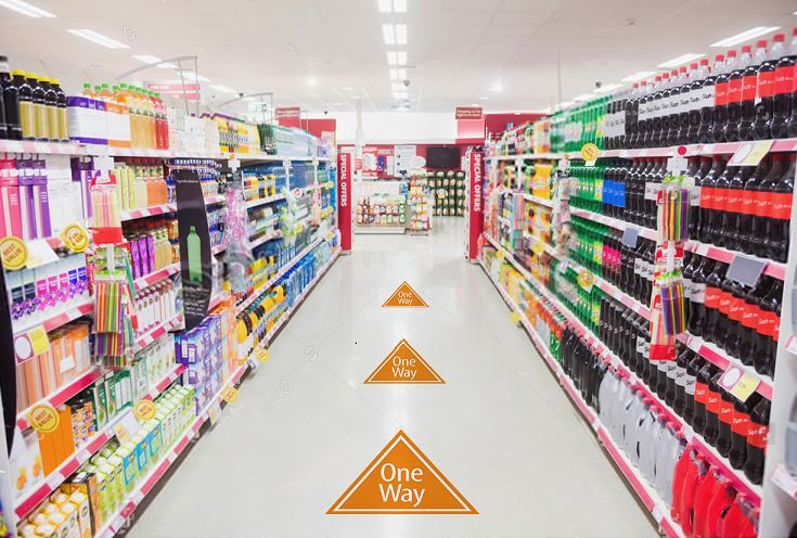 Store aisle with arrow-shaped TexWalk removable floor graphics, providing slip-resistant, durable signage for retail environments.