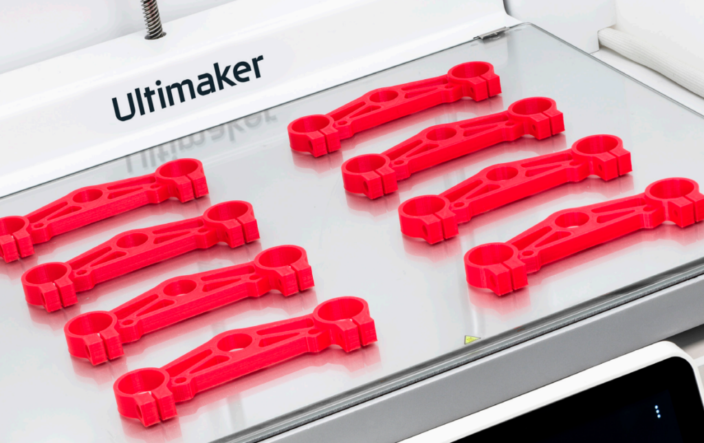 Ultimaker 3d Printer with red parts showing on the build plate