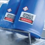 High-tack drum labels printed on Jessup TenaciousTac 2CR applied to blue chemical storage barrels