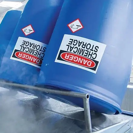 High-tack drum labels printed on Jessup TenaciousTac 2CR applied to blue chemical storage barrels