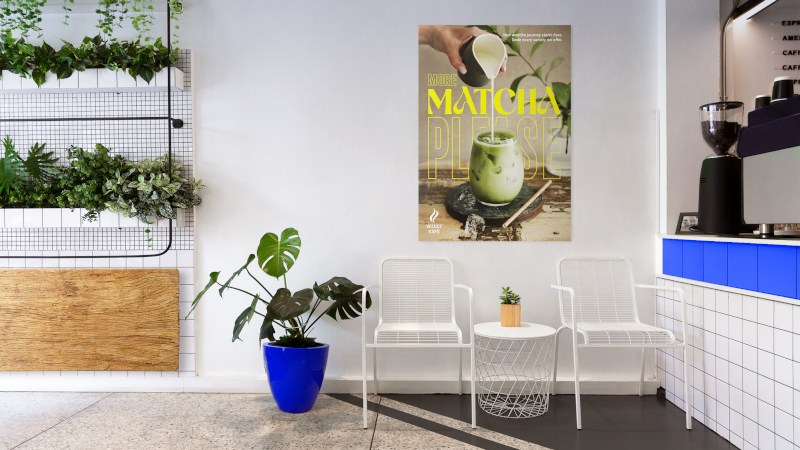 Cafe seating area with a matcha drink promotional poster on the wall